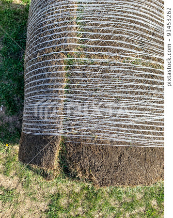 Depiction of netting being used to secure sod and dirt together for transportation to a new construction site. Depiction of netting being used to secure sod and dirt together for transportation to a new construction site. 91453262