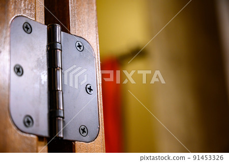 Selective focus on Oiled bronze door hinge on wood 91453326
