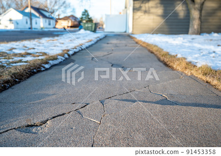 Frost heave crack in residential concrete sidewalk 91453358