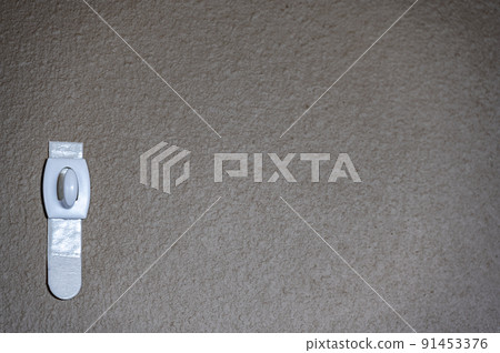 Selective focus on adhesive strip wall hanger that can be removed by pulling tape 91453376