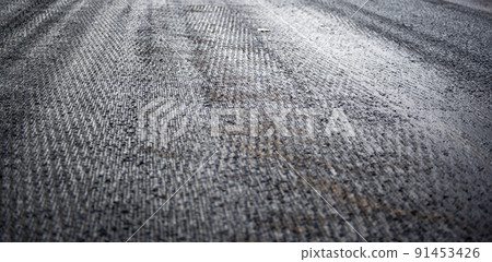 Low angle shot across a scarified street under construction with lanes on either side blocked off. Low angle shot across a scarified street under construction with lanes on either side blocked off. 91453426