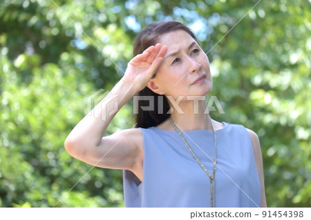 Senior woman who cares about UV rays in a hot park Senior woman who cares about UV rays in a hot park 91454398