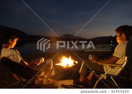 Couple bonfire outdoors 91455820