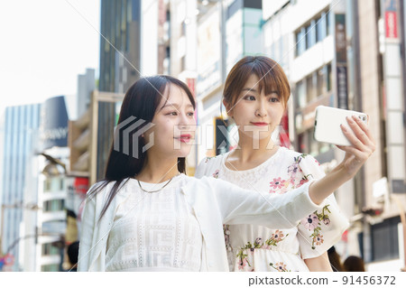 Women taking selfies in the city 91456372