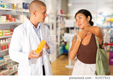 Woman complains to a pharmacist about a sore throat. Help in choosing a medicine in pharmacy Woman complains to a pharmacist about a sore throat. Help in choosing a medicine in pharmacy 91457932