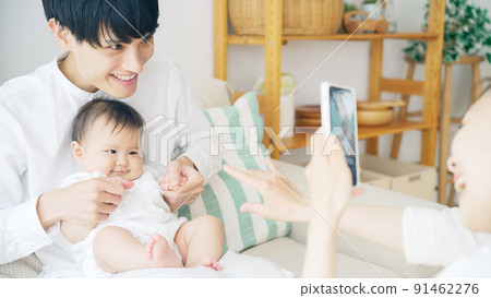 一對夫婦用智能手機拍攝嬰兒 一對夫婦用智能手機拍攝嬰兒 91462276