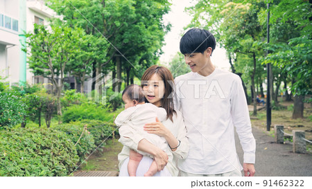 一對夫婦帶著孩子在公園散步 一對夫婦帶著孩子在公園散步 91462322