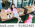 Closeup Asia little girl pose with bear on chair 91462485