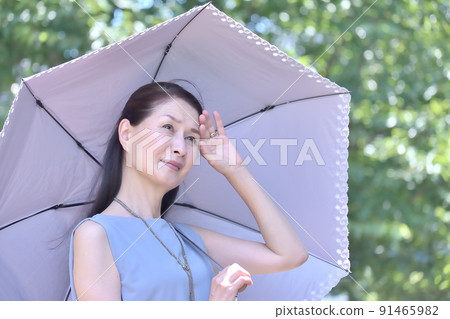 仲夏時節，在公園裡拿著遮陽傘的高級婦女，以防紫外線 91465982