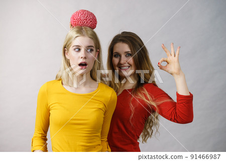 Two girls with fake brain 91466987
