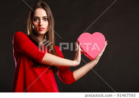 Girl in red holding heart box. 91467593
