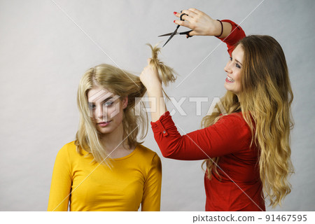 Woman with scissors ready to hair cutting 91467595