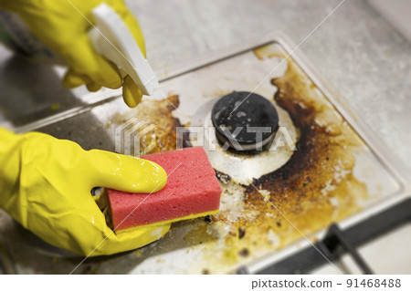 dirty kitchen stove, empty and full bottles of detergents around. 91468488