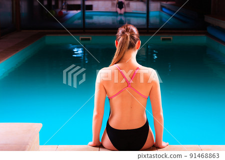 Girl swimmer muscular body  in swimsuit at poolside 91468863