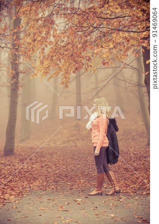 Fashion blonde woman with jacket in autumn park. Fashion blonde woman with jacket in autumn park. 91469064