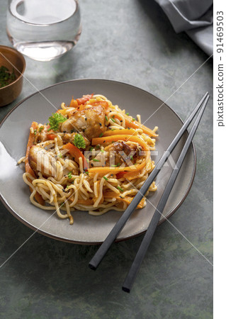 Stir fry noodles with chicken meat and vegetable, dark background. Asian style food, homemade food Stir fry noodles with chicken meat and vegetable, dark background. Asian style food, homemade food 91469503