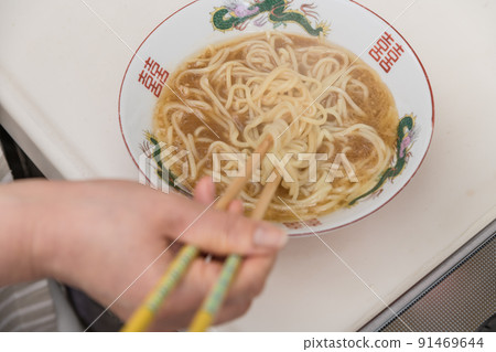 [Middle housewife puts boiled ramen noodles in a bowl] 91469644