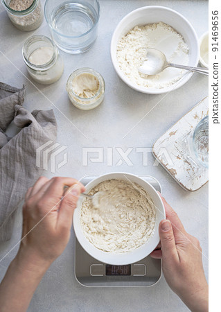 Homemade breadmaking with sourdough using wild yeast, busy lifestyle scene of baking at home, top view. Sustainable living Homemade breadmaking with sourdough using wild yeast, busy lifestyle scene of baking at home, top view. Sustainable living 91469656