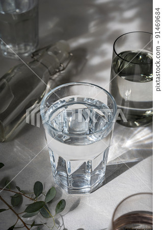 Glasses with water, abstract summer shadows on background. Drinking water concept, clean water 91469684