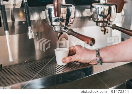 Close up view of barista hand preparing coffee espresso in automatic coffee machine in cafe Close up view of barista hand preparing coffee espresso in automatic coffee machine in cafe 91472244