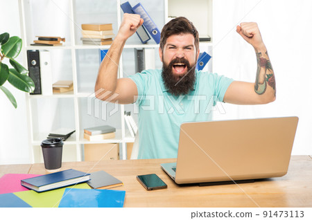 Excited guy happy screaming making winning gesture at laptop in office, victory Excited guy happy screaming making winning gesture at laptop in office, victory 91473113