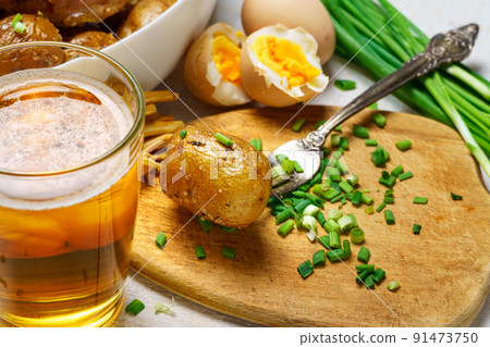 tasty lunch in rural style, healthy food - glass of beer, fried chicken meat and potatoes, garlic and green onions, cheese, boiled eggs and salt, cooked food tasty lunch in rural style, healthy food - glass of beer, fried chicken meat and potatoes, garlic and green onions, cheese, boiled eggs and salt, cooked food 91473750