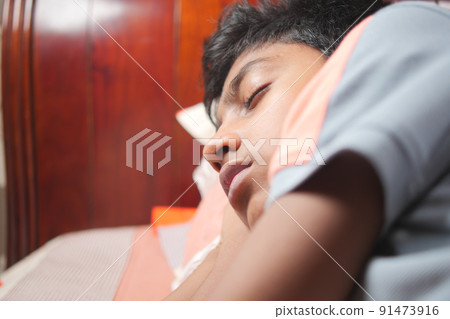 teenage boy boy sleeping in bed, selective focus . 91473916