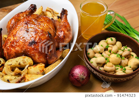 fried chicken meat and roasted potatoes on a white platter, a glass of beer, champignon mushrooms and green onions, delicious food on a wooden background fried chicken meat and roasted potatoes on a white platter, a glass of beer, champignon mushrooms and green onions, delicious food on a wooden background 91474323