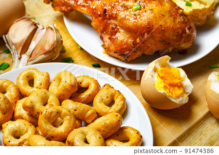 tasty and healthy food, lunch in rural style - fried chicken meat and unpeeled potatoes, eggs, green leek, salt and garlic, cooked food on a wooden kitchen board tasty and healthy food, lunch in rural style - fried chicken meat and unpeeled potatoes, eggs, green leek, salt and garlic, cooked food on a wooden kitchen board 91474386