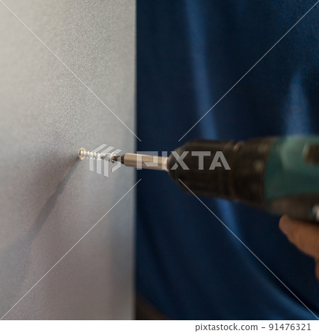 The process of screwing the screw, installation of a sliding door wardrobe. The process of screwing the screw, installation of a sliding door wardrobe. 91476321
