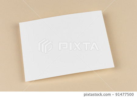 An empty blank sheet of paper on beige background. Template and mock up for invitation, letter, card, document, business design, cover and reminder. Simple minimalistic design. 91477500