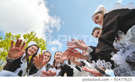 Happy Russian school graduates are stretching their hands on their last school day. 91477623