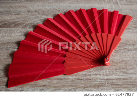 A red fan from Spain on wooden background A red fan from Spain on wooden background 91477927