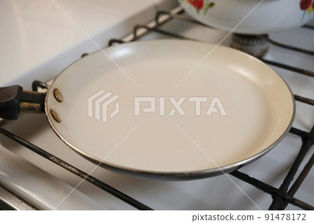 Empty frying pan on gas stove 91478172