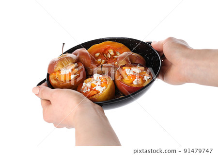 Female hands hold plate with baked apples, isolated on white background Female hands hold plate with baked apples, isolated on white background 91479747