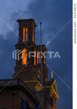Hamrun St. Gaetan Church bell tower with fairy light during national festival against blue night sky in Malta 91479870