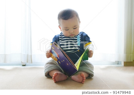 Baby reading a picture book alone 91479948