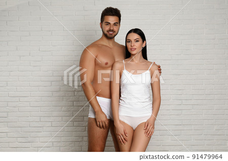 Premium Photo  Young couple in white underwear near brick wall