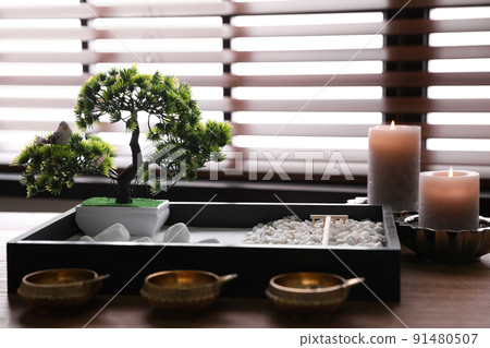 Beautiful miniature zen garden, candles and oil lamps on wooden table 91480507