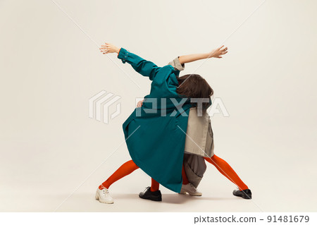 Portrait of stylish man and woman in coats and tights posing isolated over grey studio background 91481679