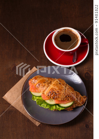 croissant with salmon and espresso, top view 91481822
