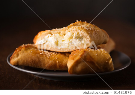 Ruddy cakes with suluguni cheese with sesame seeds on a plate 91481976