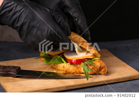 The chef puts the cheese in the croissant 91482012