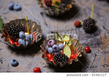 berries in vintage metal baking dishes 91482127
