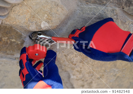 Wall faucet repair and plumber closeup. Plumbing services Wall faucet repair and plumber closeup. Plumbing services 91482548