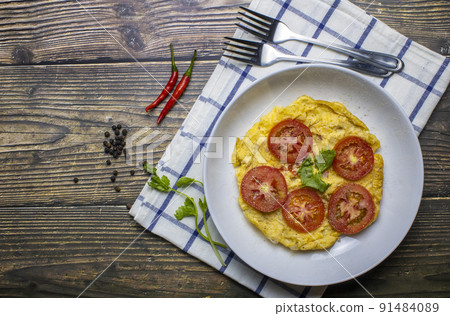 Omelette in a dish that is placed on a wooden background 91484089