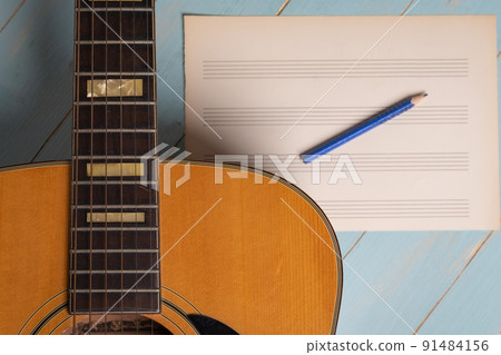 Music recording scene with guitar, empty music sheet and pencil on wooden table 91484156