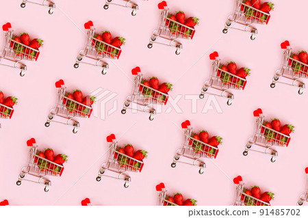 Pattern of fresh red strawberry in shopping cart on pink background. Online shopping and Valentines Day minimalistic concept. Black Fridays sales banner. Healthy, organic, vegan food 91485702