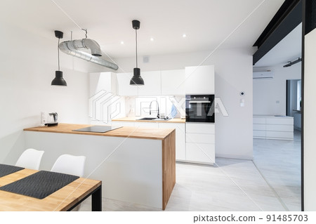 Modern kitchen with a dining area and a counter. 91485703
