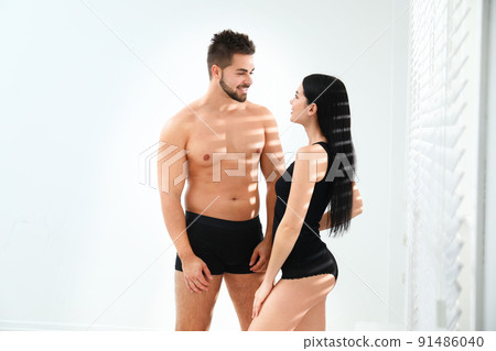 Young couple in black underwear near window indoors 91486040